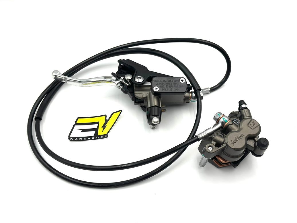 A motorcycle brake assembly featuring a black master cylinder with a long black hose, a silver lever, and a gray brake caliper, displayed on a clean white background with a yellow and black logo sticker. Surron ultra bee brake assembly rear pre bled