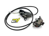 A motorcycle brake assembly featuring a black master cylinder with a long black hose, a silver lever, and a gray brake caliper, displayed on a clean white background with a yellow and black logo sticker. Surron ultra bee brake assembly rear pre bled