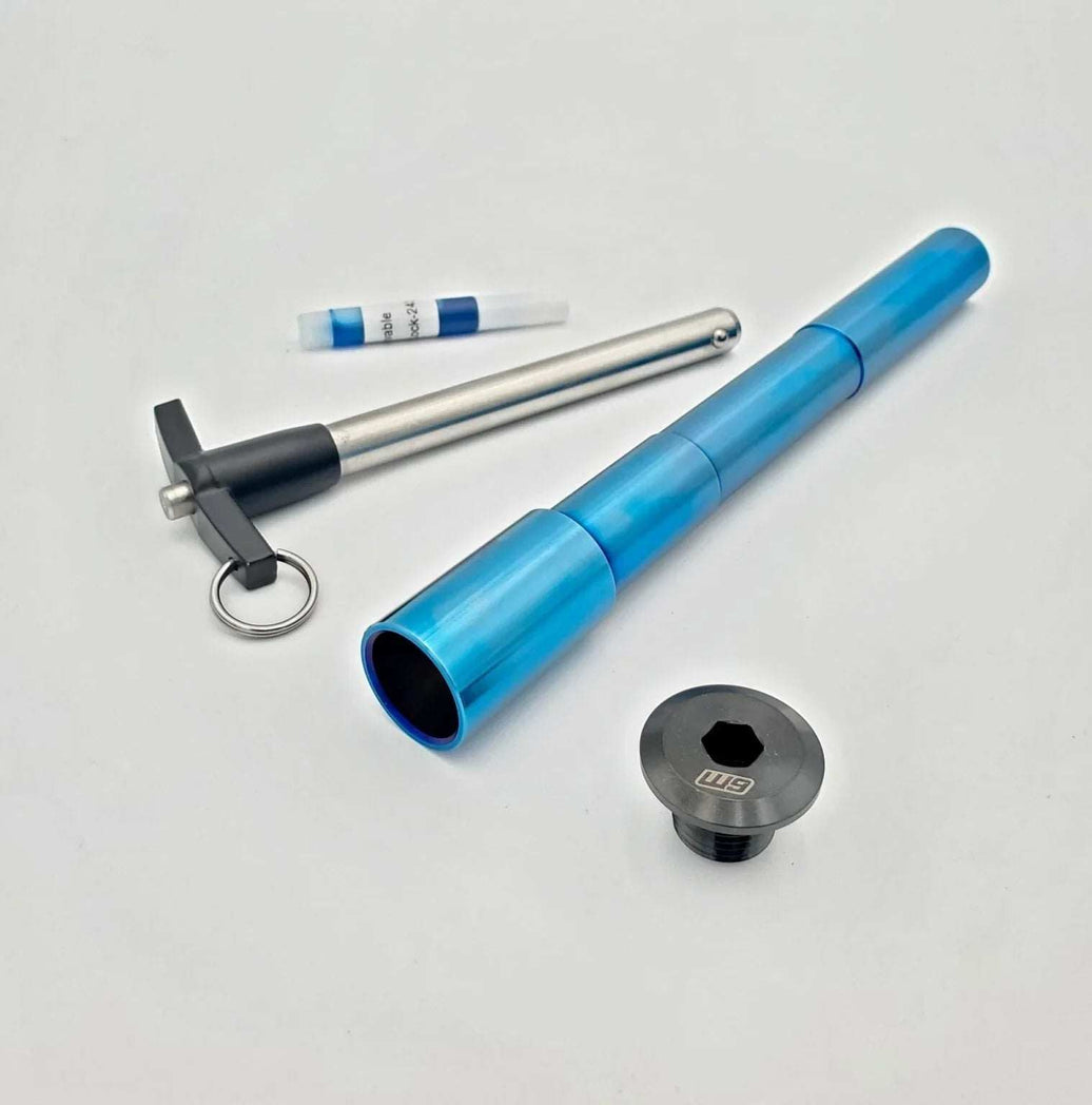 Warp 9 Surron Ultra Bee titanium front axle with quick pull handle and burnt blue anodized finish